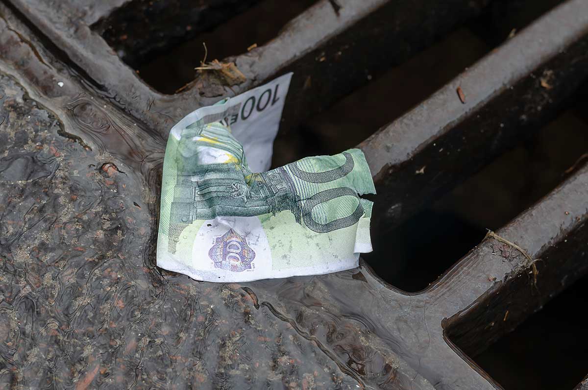 Nota de 100 euros no chão e molhada